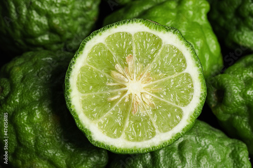 Whole and cut ripe bergamot fruits as background, top view