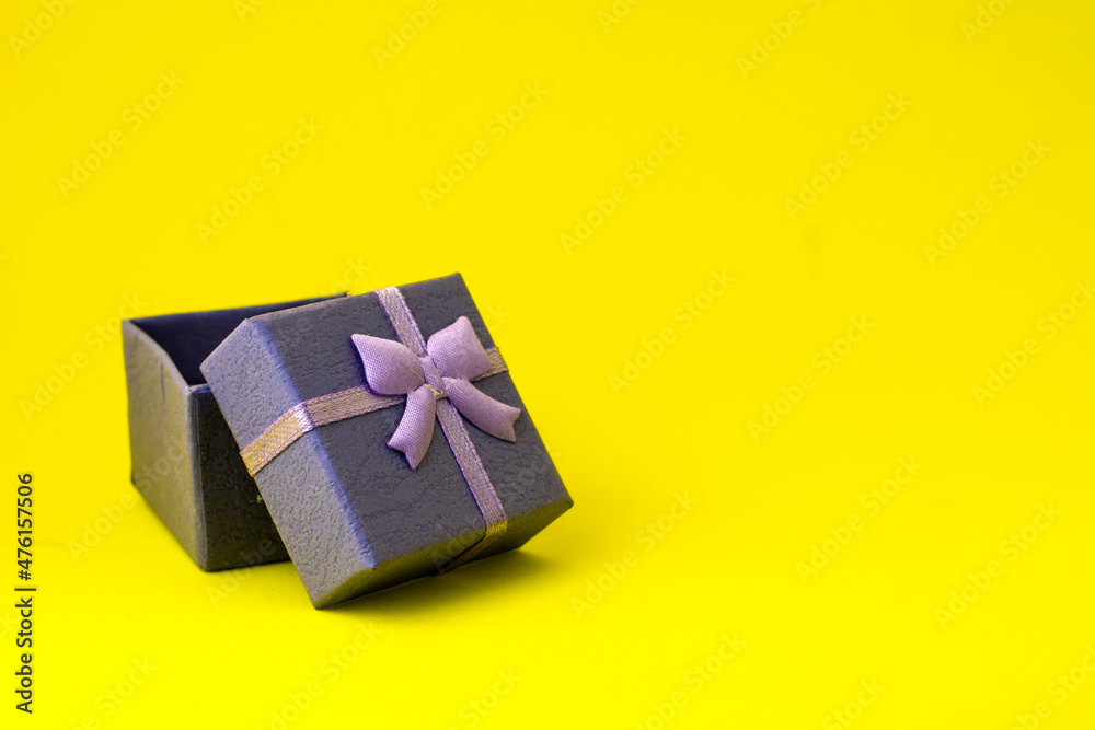 blue gift box with an open lid on a yellow background with copyspace blue gift box with an open lid on a yellow background with copyspace