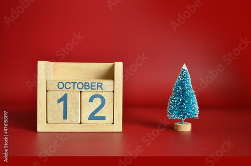 October 12, Calendar design with Christmas tree on red table background. photo