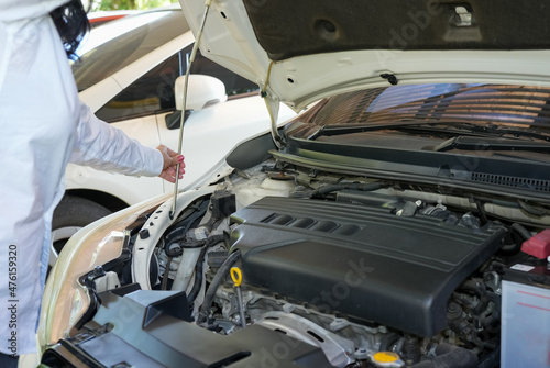 Vehicle safety concept, Woman's hand checking car engine before driving.