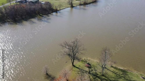 slow dolly tilt pan over jacobson park in lexington kentucky, showing a massive lake and park visitors with blue skies 4k photo