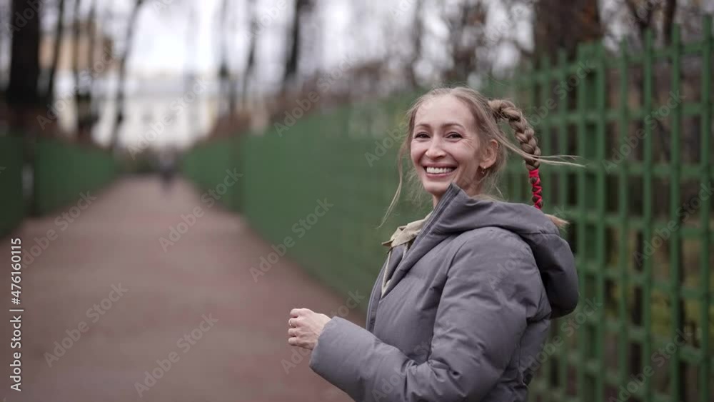 positive woman with funny hairstyle is walking on city street, playing with her comical braids positive woman with funny hairstyle is walking on city street, playing with her comical braids