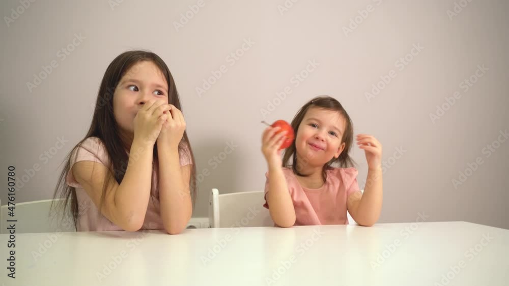 Children eat healthy food. Little girls eat red apples. Proper nutrition for children. Vitamins in the red apple. Children eat healthy food. Little girls eat red apples. Proper nutrition for children. Vitamins in the red apple.