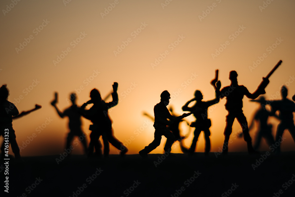 Silhouette of toy soldiers in front of the sun during the sunset. Soldiers background. War background. Soldiers in war concept