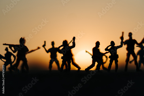 Silhouette of toy soldiers in front of the sun during the sunset. Soldiers background. War background. Soldiers in war concept