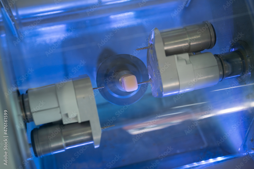 Dental milling machine carving out shape of human teeth close-up ...