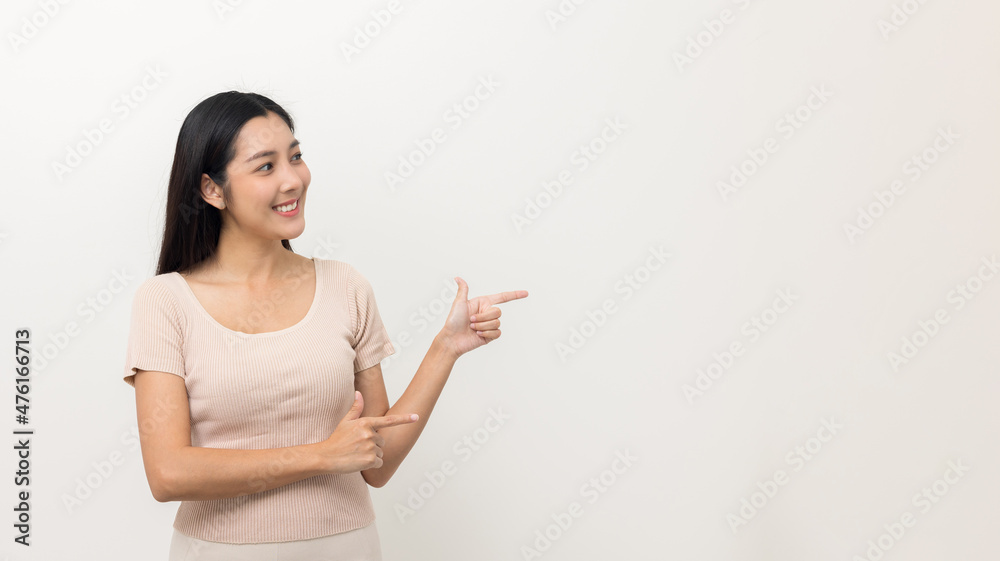 Beautiful asian woman pointing finger into blank space. Smiling female standing pose on isolated white background. Attractive Teenager girl around 25 looking at empty space for advertise text. Beautiful asian woman pointing finger into blank space. Smiling female standing pose on isolated white background. Attractive Teenager girl around 25 looking at empty space for advertise text.