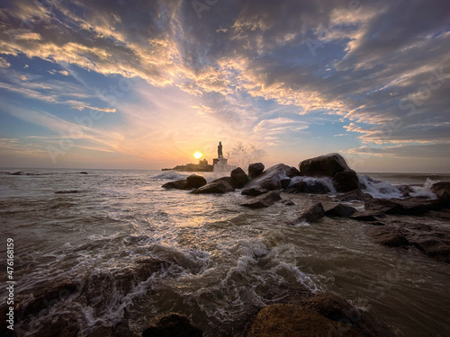 Lighthouse on the wavy seashore in Kanyakumari India at sunset photo