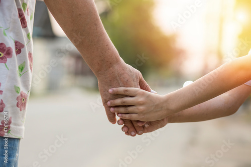 parent holds the hand of a small child