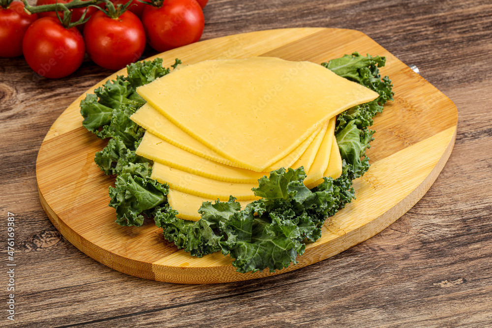 Sliced Gauda cheese over board Sliced Gauda cheese over board