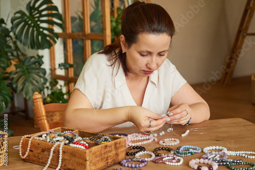 Woman makes handmade gemstone beads in her home workshop