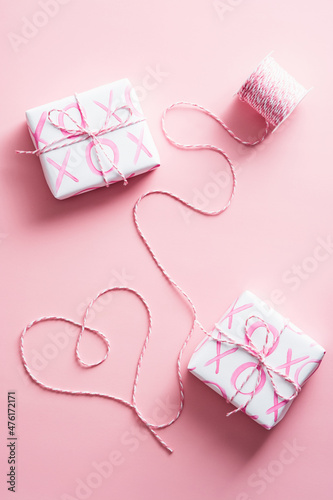 Gift boxes and heart shaped ribbon on pink background. Happy Valentines day composition.