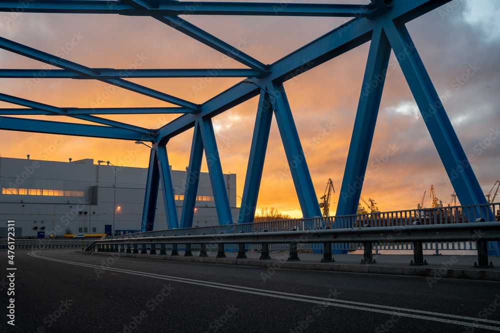 Asphalt road leading through an industrial area,image perfect as a background for 3d rendering