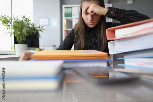 Fotografie Tired overworked woman with hopeless look on docs pile