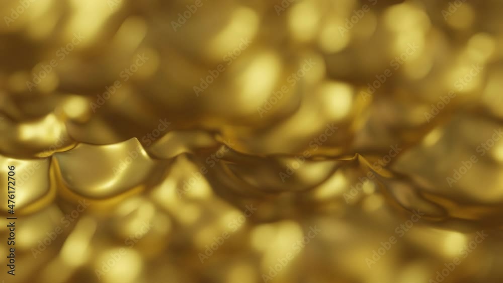 Gold liquid waves in slow motion with a narrow depth of field. Celebration gold bokeh animation background.