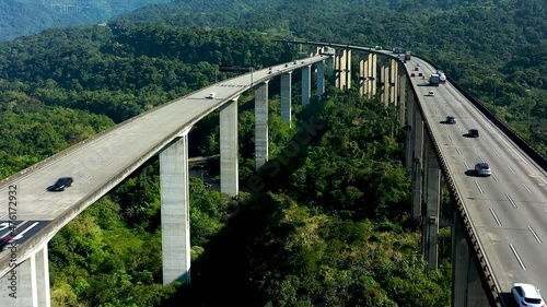 Aerial landscape of landmark highway road at green forest trees and mountains. Traffic at famous road way to brazilian south coast. Legendary engineering construction. Brazilian road landmark. photo