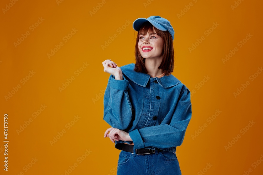 pretty woman in a cap and denim jacket posing yellow background unaltered pretty woman in a cap and denim jacket posing yellow background unaltered