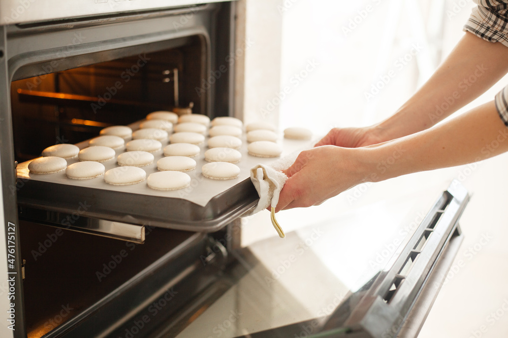 close-up of woman makes macaroons and puts it in the oven baked close-up of woman makes macaroons and puts it in the oven baked