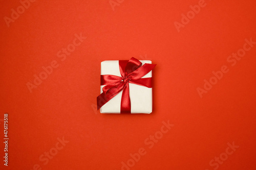 Gift box with red ribbon bow on red background. Top view © aleksashka_89