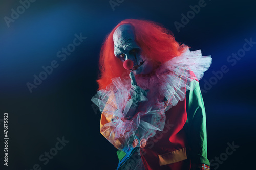 Foto Terrifying clown on black background. Halloween party costume