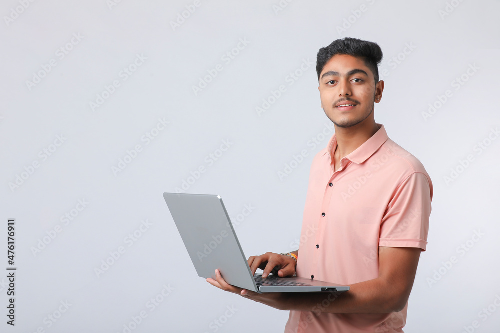 Young indian man using laptop on white background. Young indian man using laptop on white background.