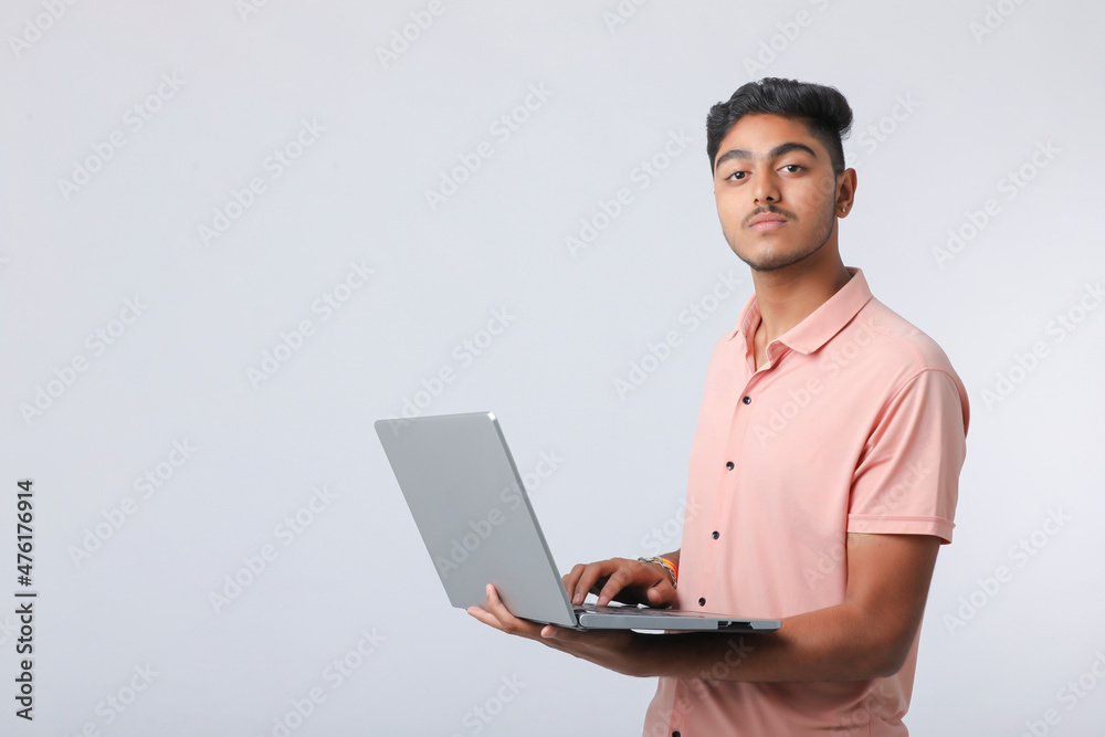 Young indian man using laptop on white background. Young indian man using laptop on white background.