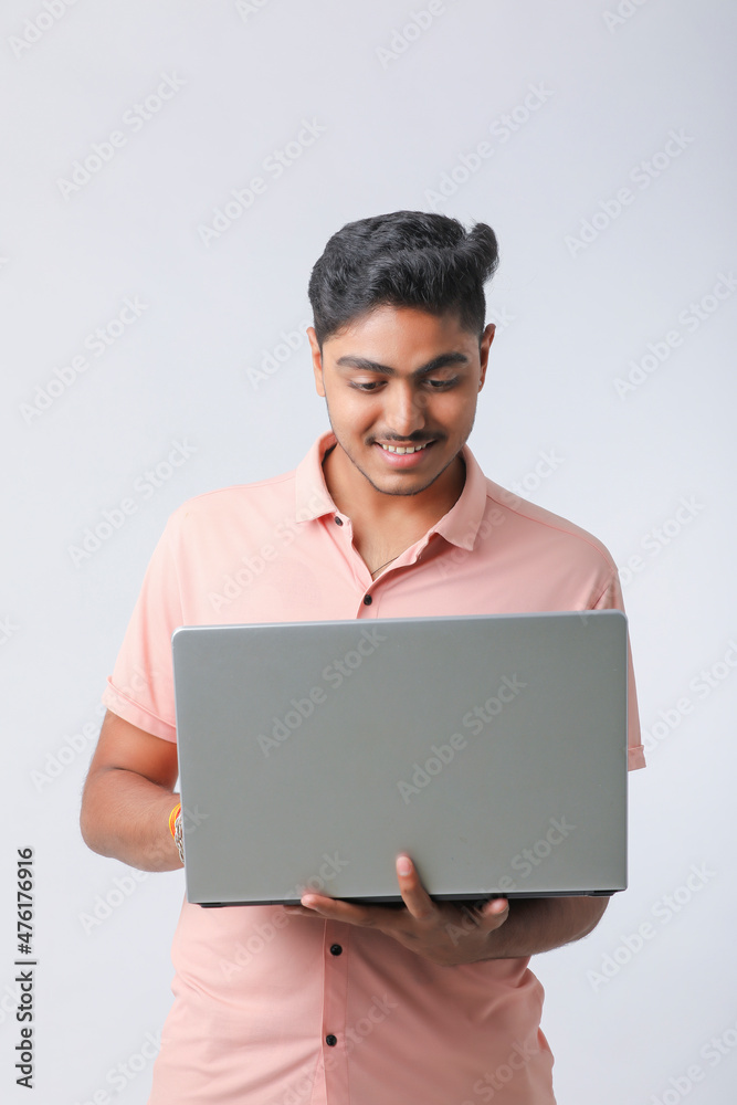 Young indian man using laptop on white background. Young indian man using laptop on white background.