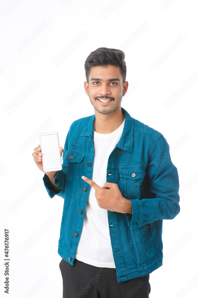 Young indian man showing smartphone screen on white background. Young indian man showing smartphone screen on white background.