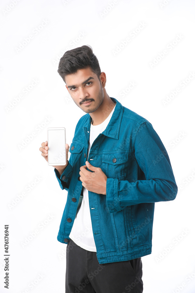 Young indian man showing smartphone screen on white background. Young indian man showing smartphone screen on white background.