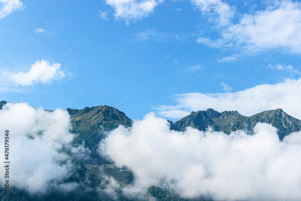 Thick white clouds float in the mountains. Beautiful mountain landscape. Nature background 