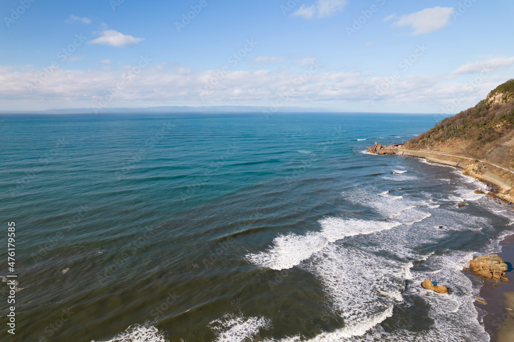冬の日本海の岬の海岸にうち寄せる波　ドローン空撮　俯瞰撮影