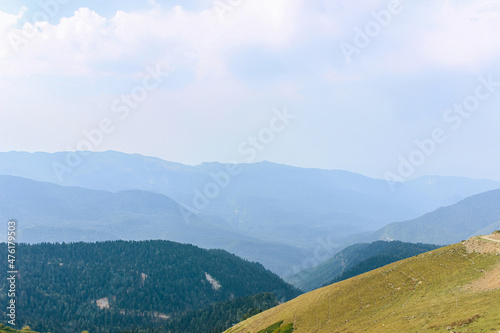 Blue mountains covered with forests. View from the green hill Beautiful mountain landscape. Nature background 