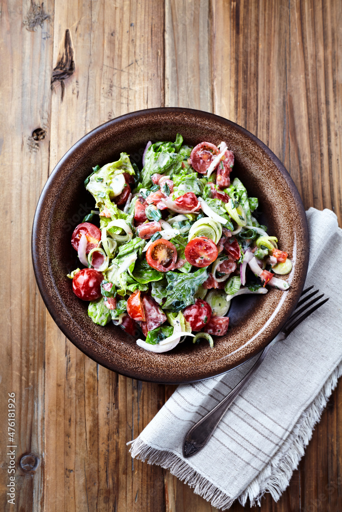 Simple Salad with Cherry Tomatoes, Lettuce, Red Pepper, Leek and Onion. Dark wooden background. Top view. 