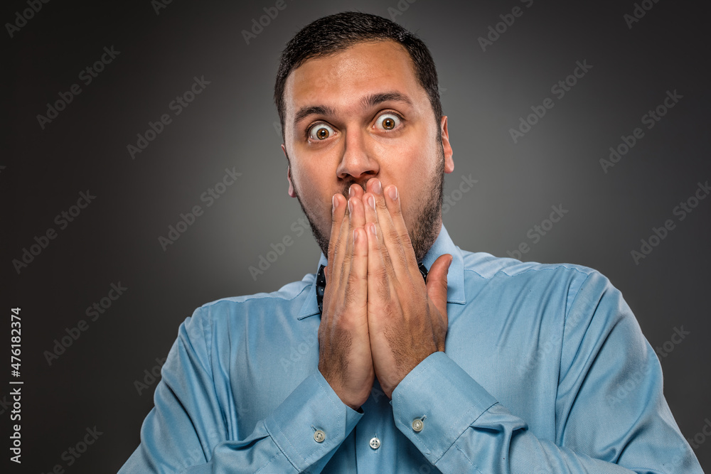 Portrait young man in blue shirt, looking with amazement Portrait young man in blue shirt, looking with amazement