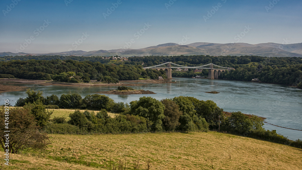 The menai suspension bridge is a suspension bridge to carry road traffic between the island of Anglesey and the mainland of Wales.