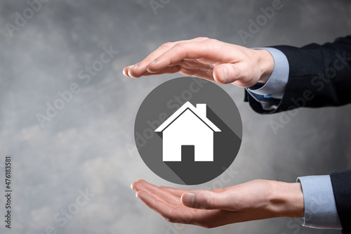 Real estate concept, businessman holding a house icon.House on Hand.Property insurance and security concept. Protecting gesture of man and symbol of house.flat icons with long shadows
