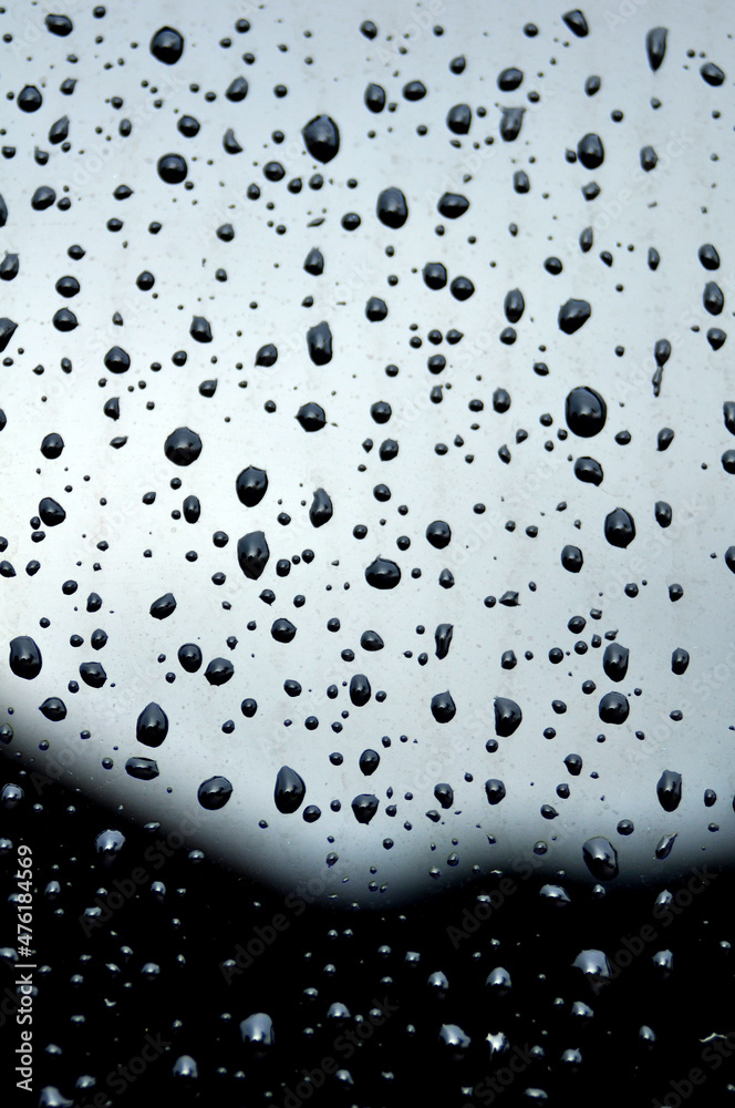 The deep water droplets on the black surface and some of the water droplets are blurry
