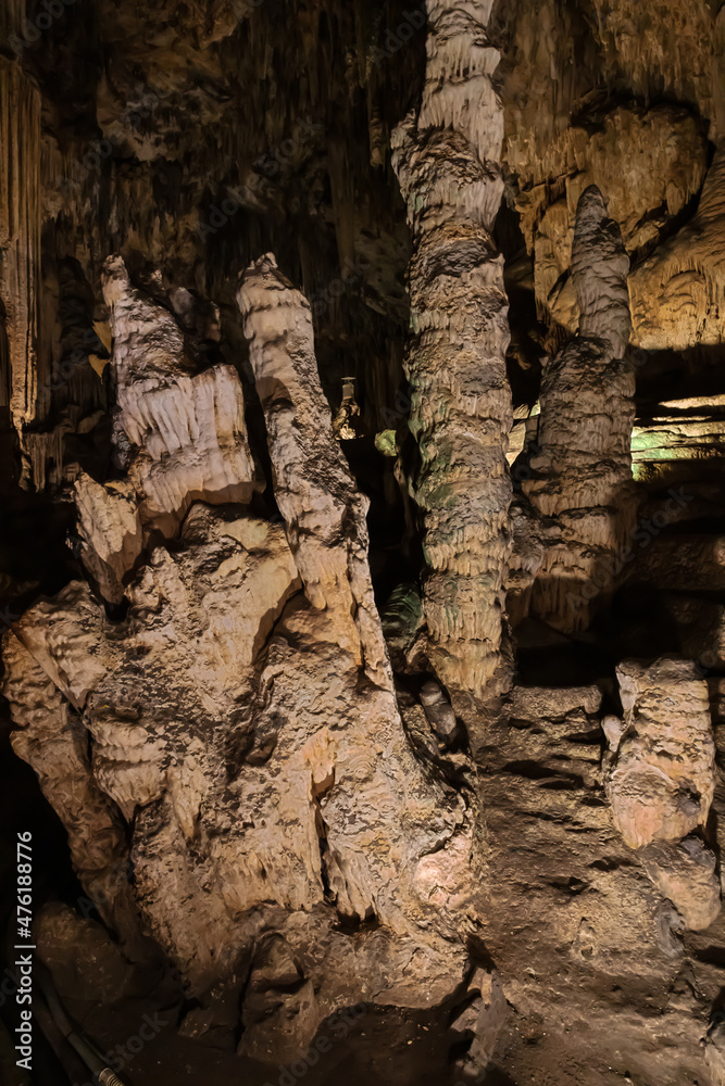 Stalactites with a polished structure at the entrance of the Nerja cave. Selective focus on the nearby formation.