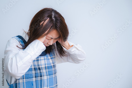 忙し過ぎてストレスで頭を抱えるミドル層の日本人女性 主婦のイメージ photo