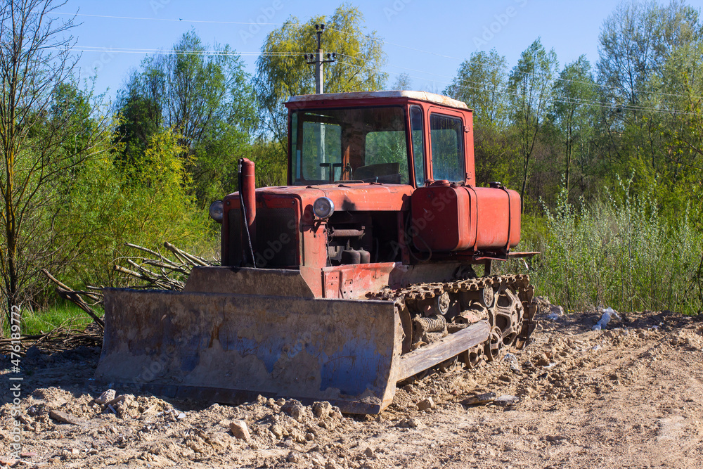 Old dirty red bulldozer. Front view.