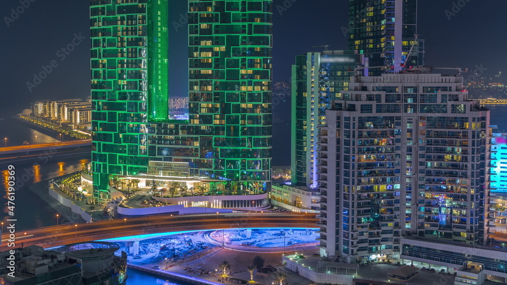 Fototapeta premium Promenade and Dubai cityscape seen from Dubai marina night timelapse. Aerial view to JBR district and Bluewaters Island behind