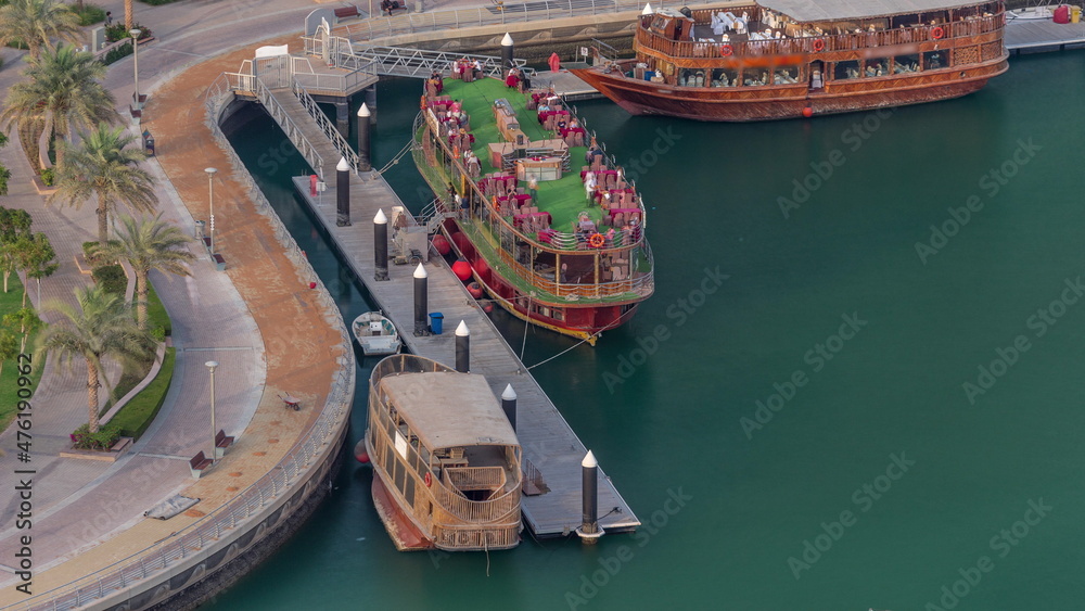 Old wooden ship near waterfront promenade aerial timelapse.