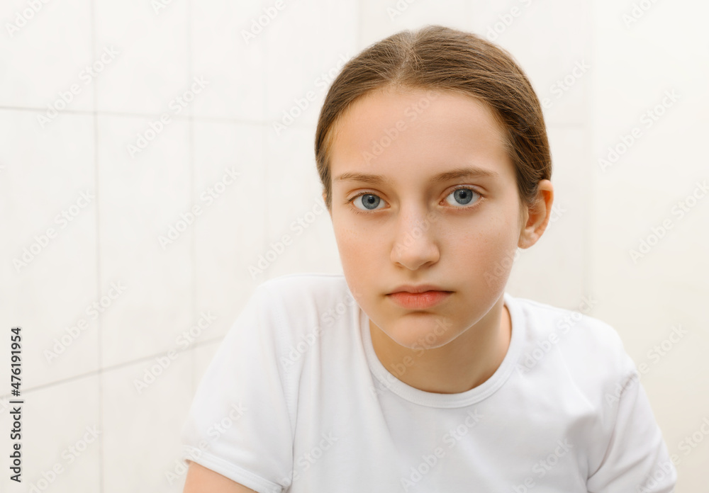 face of a teenage girl, she looks at herself in the mirror and smiling, good and clean skin is a concept of beauty and health face of a teenage girl, she looks at herself in the mirror and smiling, good and clean skin is a concept of beauty and health