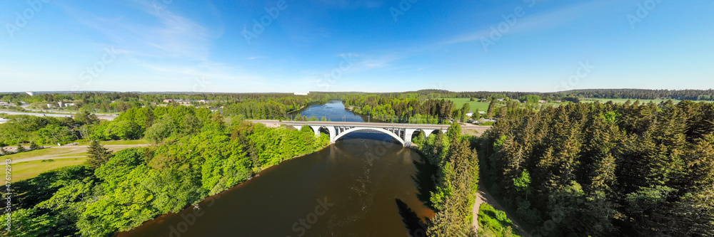Naklejka premium Summer panoramic aerial view of bridge and Kymijoki river waters in Finland, Kymenlaakso, Kouvola, Koria