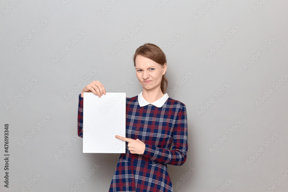 Portrait of disgruntled young woman holding white blank paper sheet Portrait of disgruntled young woman holding white blank paper sheet
