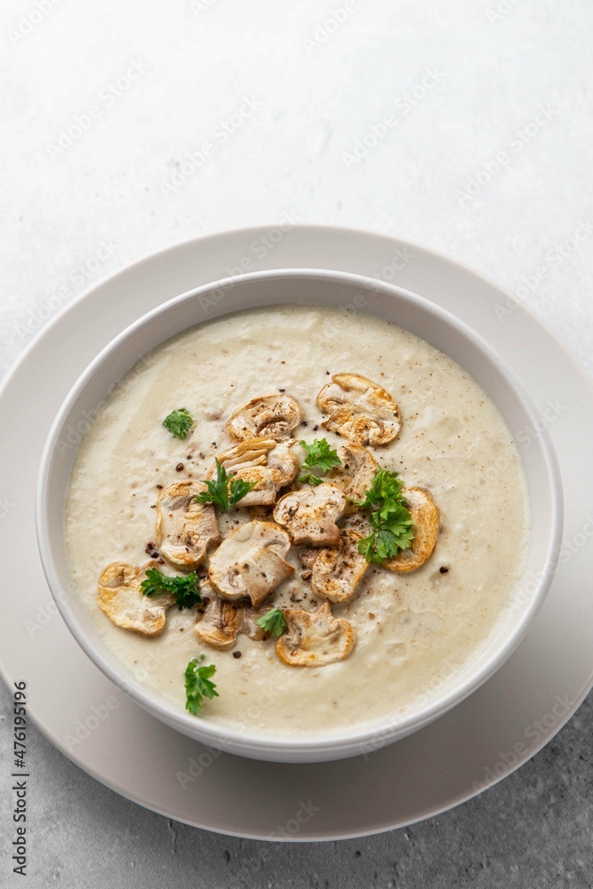 Bowl with mushroom champignon cream soup on grey table. Top view, copy space. Selective focus. Bowl with mushroom champignon cream soup on grey table. Top view, copy space. Selective focus.