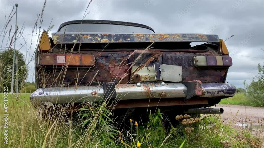 old rusty car on the street in summer