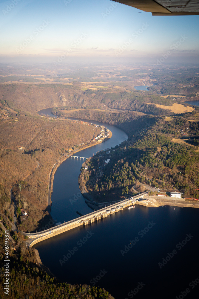Naklejka premium Beautiful aerial view of countryside during sunset from a Plane window Orlik Reservoir on Vltava River is largest hydroelectric dam in Czech Republic. Important source of sustainable energy in Europe
