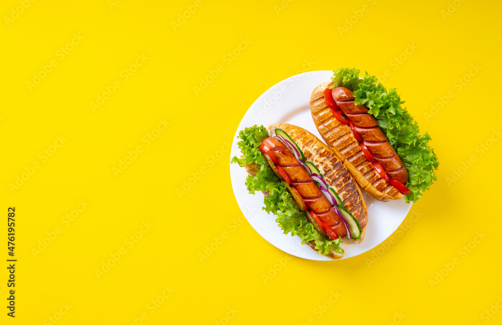 Grilled Hot Dogs on yellow background, top view. Flat lay with copy space.