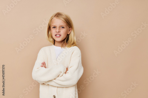 Positive little girl in a sweater, grimaces kids lifestyle concept © SHOTPRIME STUDIO
